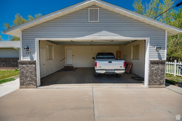 garage featuring fence and driveway