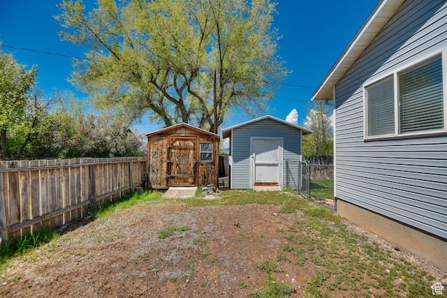 fenced backyard featuring a storage shed and an outdoor structure