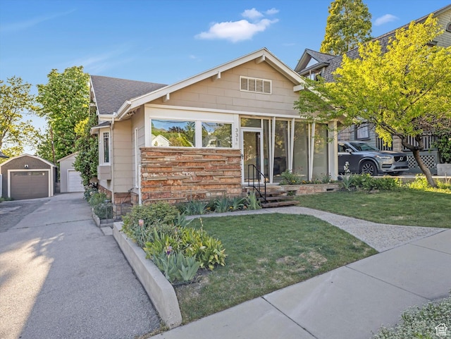 331 N K St, Salt Lake City, UT 84103 - view of front of property with a detached garage, an outbuilding, a front yard, and roof with shingles