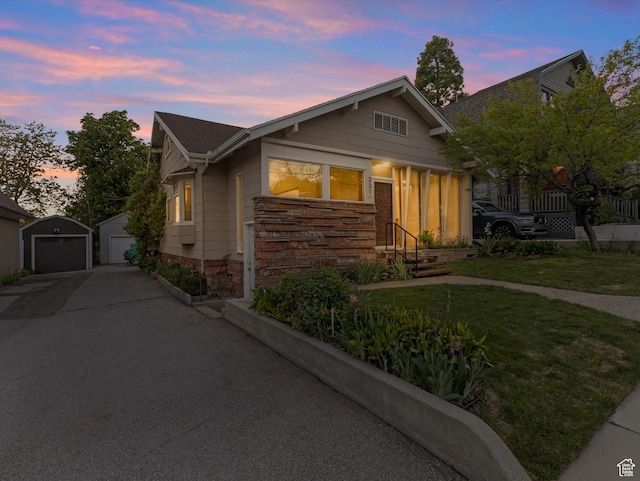 331 N K St, Salt Lake City, UT 84103 - view of front of property with stone siding, an outdoor structure, a garage, entry steps, and a lawn
