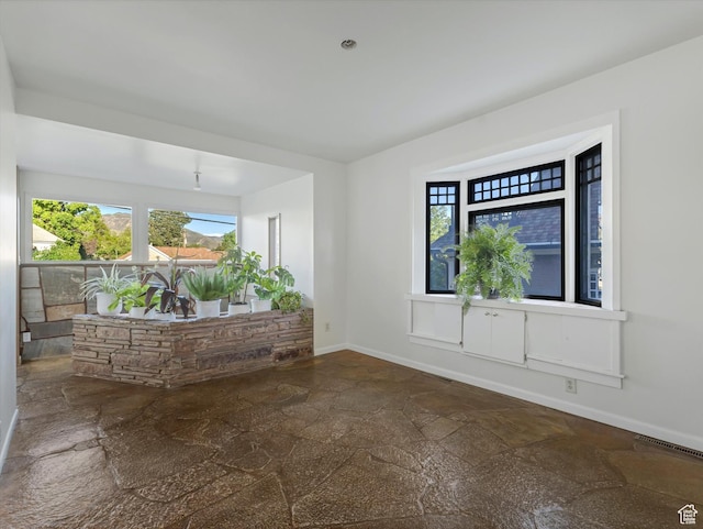 331 N K St, Salt Lake City, UT 84103 - unfurnished room featuring stone tile flooring, healthy amount of natural light, and baseboards