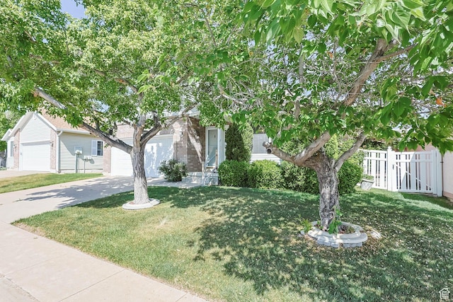 1660 E 900 S Unit 29, Clearfield, UT 84015 - view of property hidden behind natural elements featuring driveway, an attached garage, and brick siding