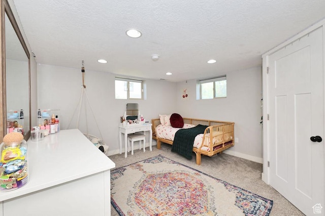 bedroom with light carpet, a textured ceiling, recessed lighting, and baseboards