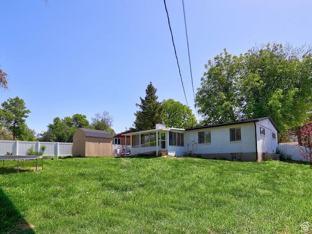 back of property with a storage unit, a sunroom, and an outbuilding