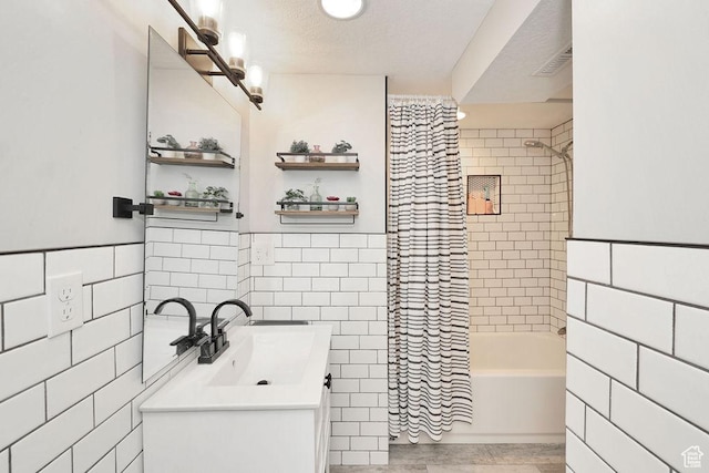 bathroom featuring tile walls, vanity, and shower / tub combo with curtain