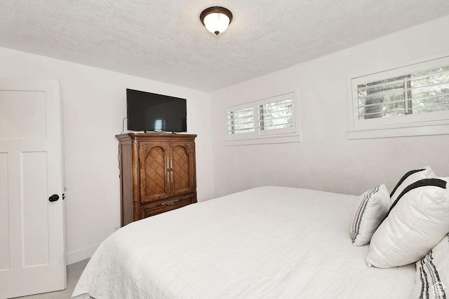 bedroom featuring a textured ceiling and carpet