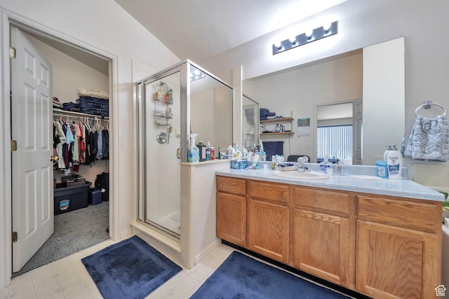 bathroom featuring a shower stall, vanity, and a spacious closet