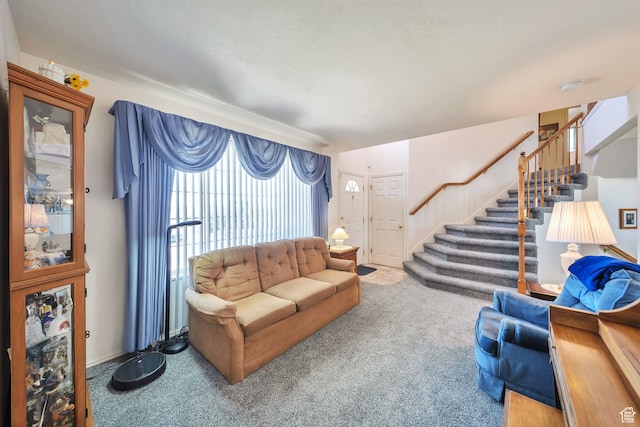 carpeted living area featuring stairway