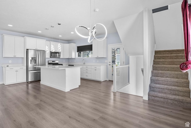 834 W Shelton Way, Midvale, UT 84047 - kitchen with appliances with stainless steel finishes, a sink, light countertops, a kitchen island, and wood finished floors