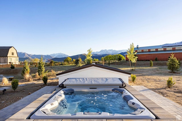 view of pool with a mountain view and a covered hot tub