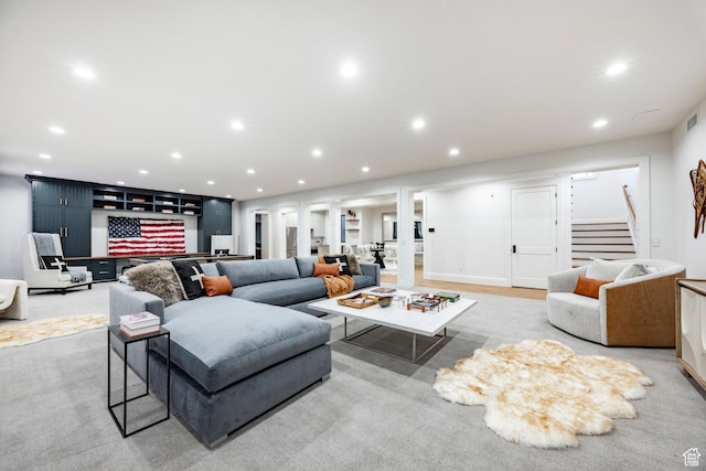 living area featuring stairs, recessed lighting, decorative columns, and bar