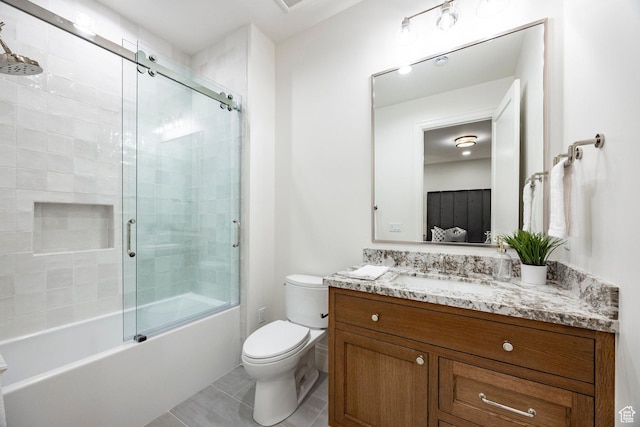 full bath featuring toilet, tile patterned flooring, vanity, and enclosed tub / shower combo