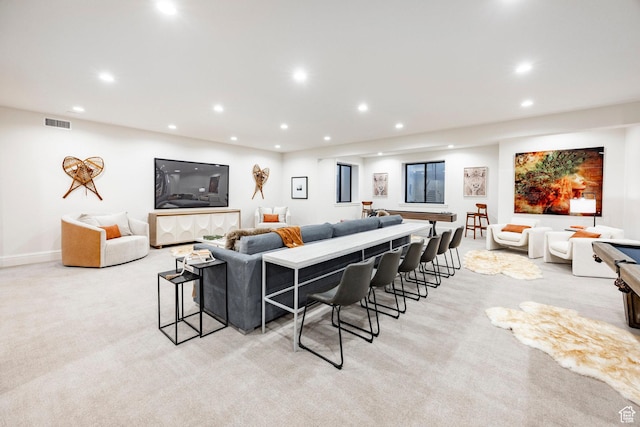 living area featuring recessed lighting and light carpet