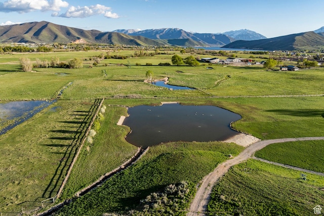 aerial view of property and surrounding area featuring rural landscape and a water and mountain view