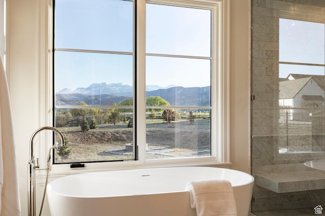 full bath with a mountain view, a freestanding tub, and tiled shower