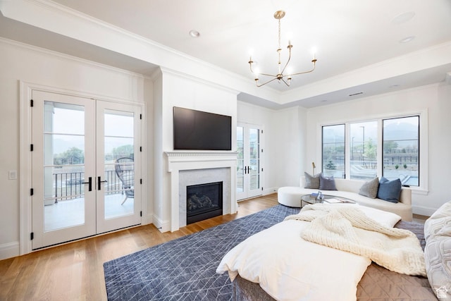 bedroom with french doors, access to outside, a chandelier, light wood-style flooring, and crown molding