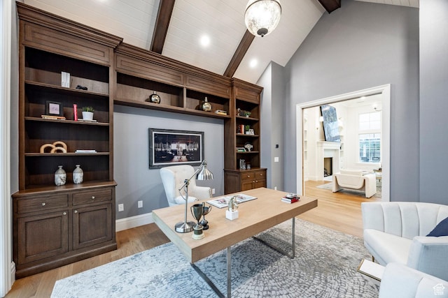 office area featuring a fireplace, light wood-type flooring, and baseboards
