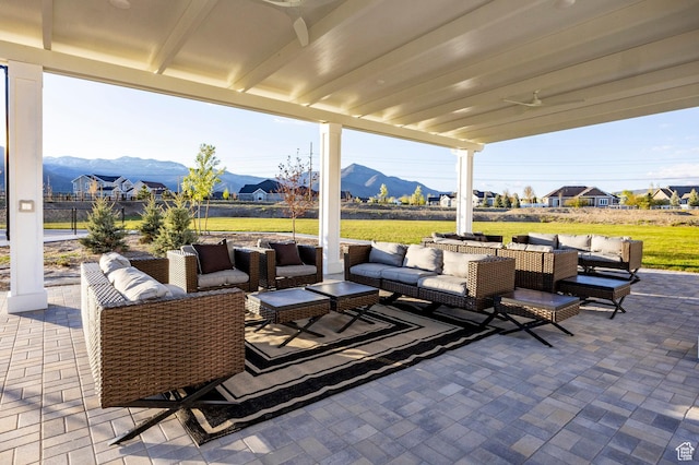 view of patio / terrace with an outdoor living space, a mountain view, and ceiling fan