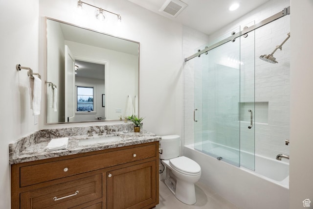 bathroom featuring vanity, toilet, and shower / bath combination with glass door