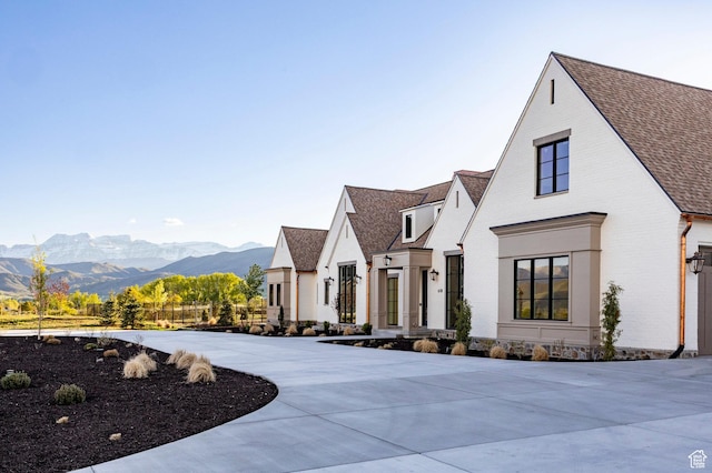 view of front of home with a mountain view, brick siding, and a shingled roof