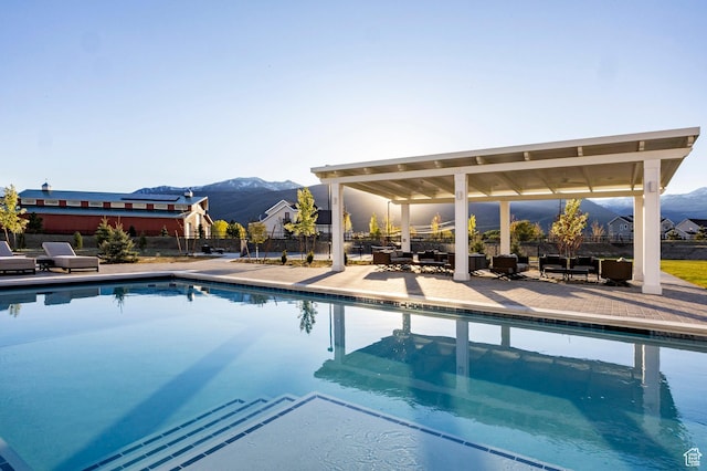 view of pool featuring a mountain view, a patio, fence, and outdoor lounge area