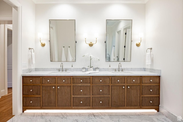 full bath featuring double vanity, ornamental molding, and baseboards