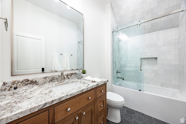 full bathroom featuring toilet, tile patterned floors, vanity, and combined bath / shower with glass door