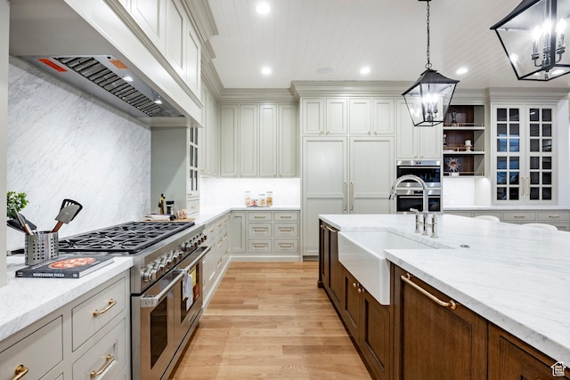 kitchen featuring premium range hood, a chandelier, appliances with stainless steel finishes, light wood-style flooring, and recessed lighting