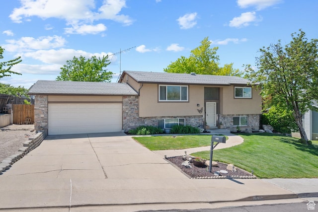 split foyer home featuring stone siding, an attached garage, and driveway