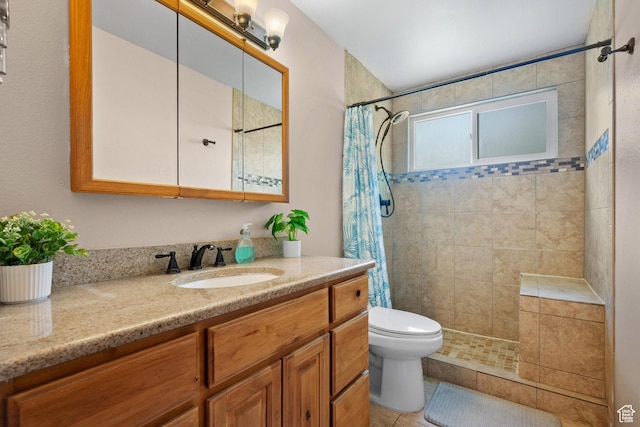 bathroom featuring a tile shower, toilet, vanity, and tile patterned floors