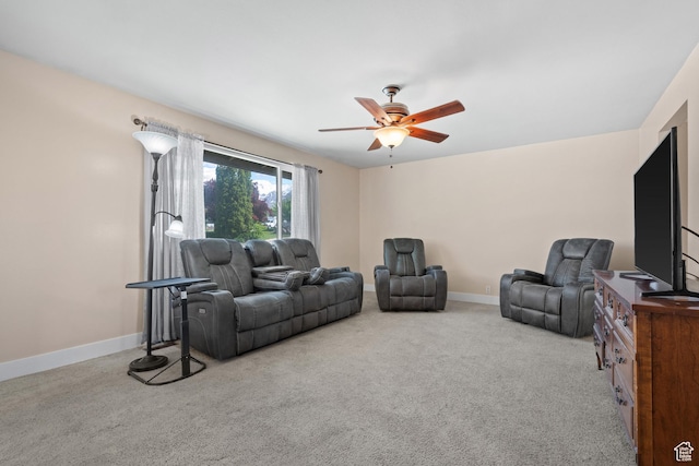 carpeted living room featuring a ceiling fan and baseboards
