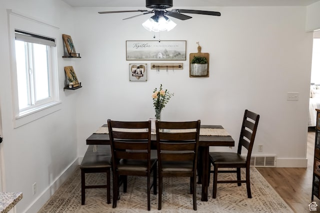 dining room with a ceiling fan, baseboards, and wood finished floors