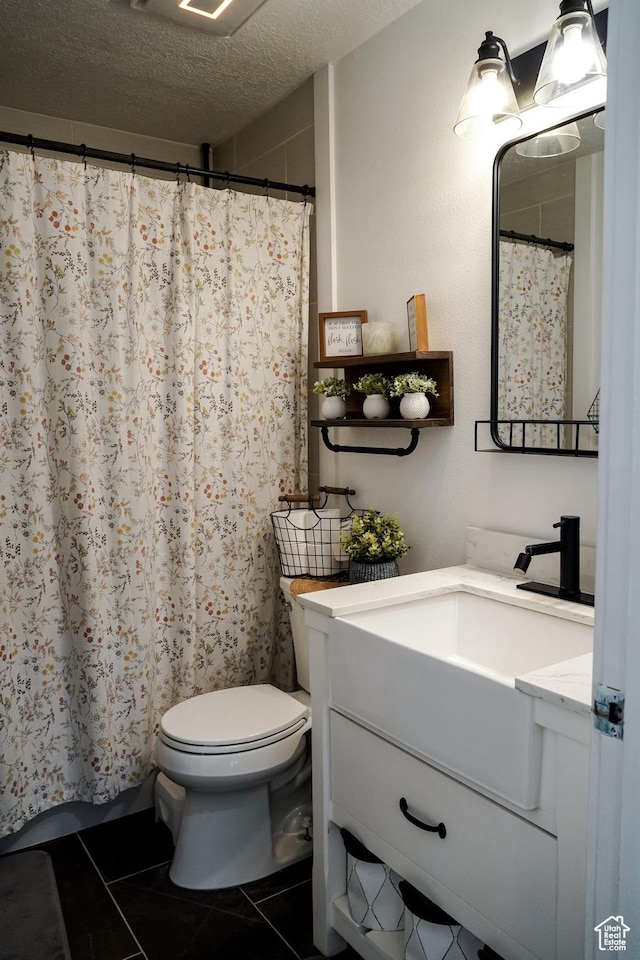 full bath with vanity, tile patterned flooring, toilet, a shower with shower curtain, and a textured ceiling