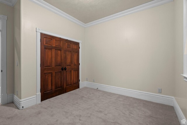 unfurnished bedroom with carpet floors, ornamental molding, and baseboards