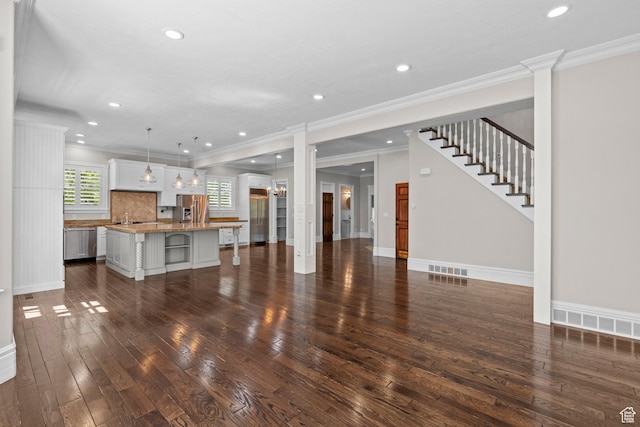 unfurnished living room with dark wood finished floors, recessed lighting, a sink, crown molding, and baseboards