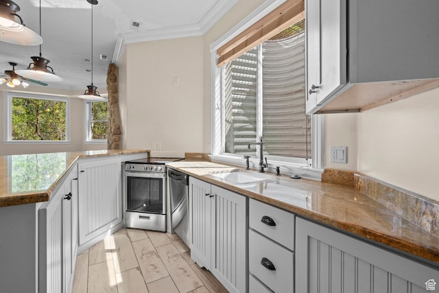 kitchen featuring a sink, stainless steel appliances, crown molding, a ceiling fan, and light stone counters