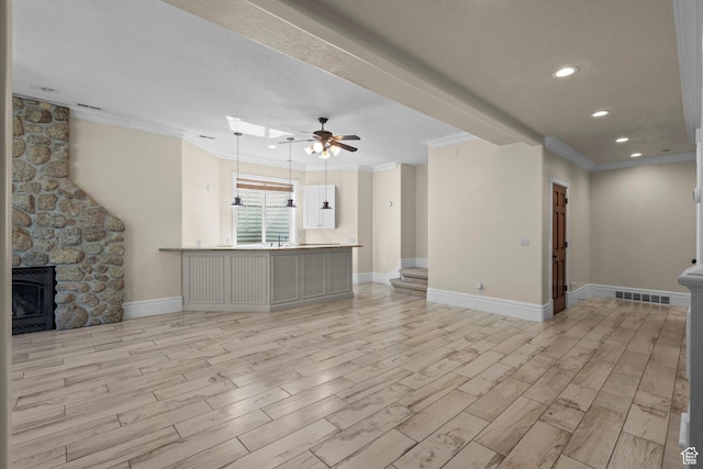 unfurnished living room featuring ornamental molding, light wood-style floors, ceiling fan, baseboards, and a fireplace