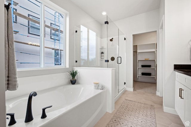 full bathroom featuring a bath, a stall shower, vanity, and tile patterned floors