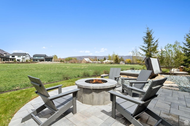 view of patio / terrace with a fire pit and a hot tub
