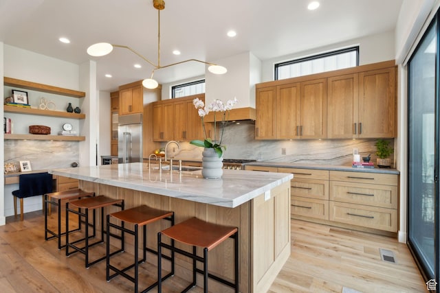 kitchen featuring built in refrigerator, a sink, plenty of natural light, tasteful backsplash, and recessed lighting