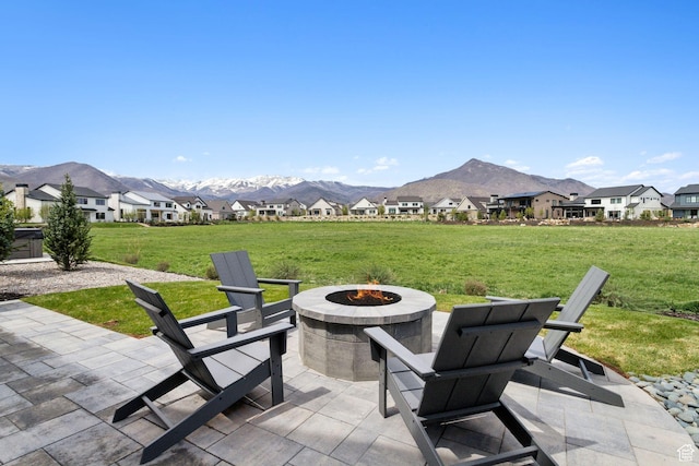 view of patio / terrace with an outdoor fire pit, a mountain view, and a residential view