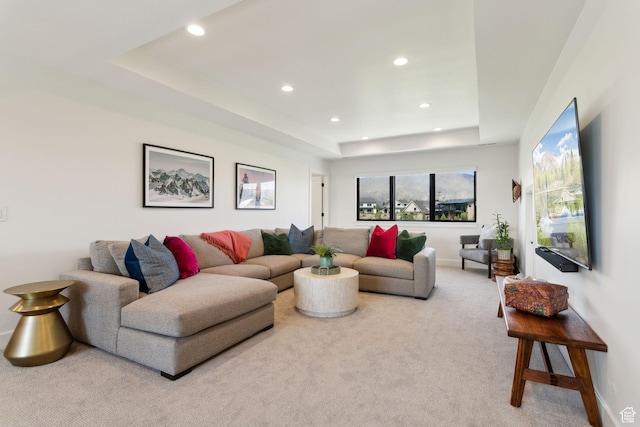 carpeted living room featuring recessed lighting, a tray ceiling, and baseboards
