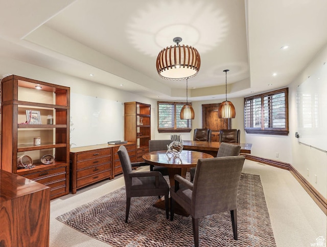 dining room featuring a tray ceiling, light colored carpet, recessed lighting, and baseboards