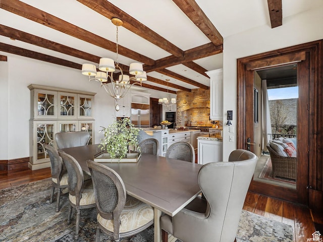 dining space with a chandelier, wood finished floors, beam ceiling, and baseboards