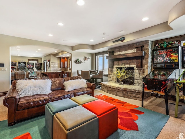 living area with arched walkways, carpet, a fireplace, and recessed lighting