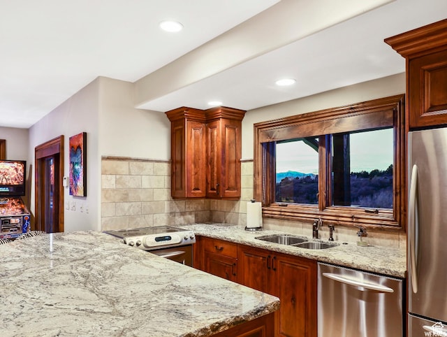 kitchen featuring stainless steel appliances, a sink, light stone countertops, tasteful backsplash, and recessed lighting