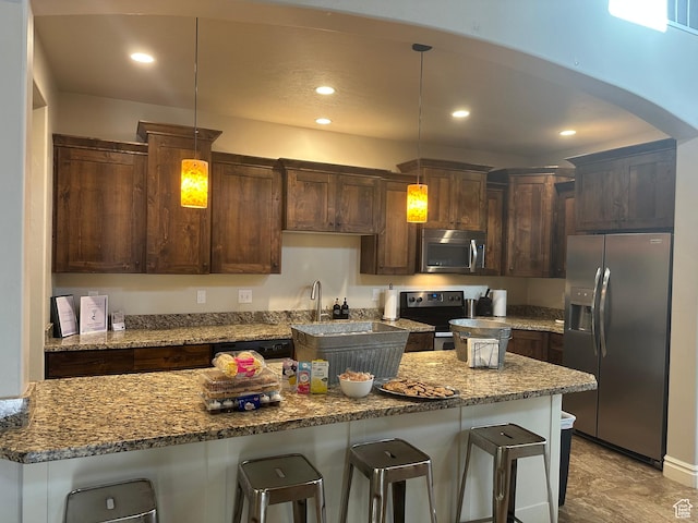 5516 W Florence Ln N, Highland, UT 84003 - kitchen with appliances with stainless steel finishes, a kitchen bar, recessed lighting, and dark brown cabinets