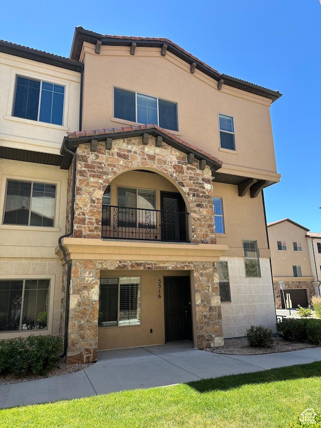 5516 W Florence Ln N, Highland, UT 84003 - back of property featuring a balcony, stone siding, stucco siding, and a tile roof