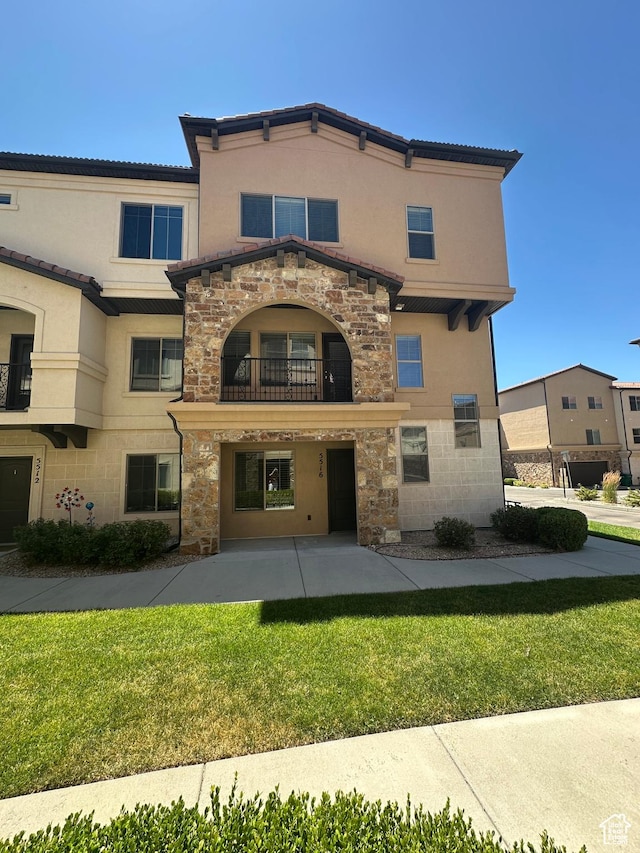 5516 W Florence Ln N, Highland, UT 84003 - back of property featuring stone siding, a balcony, a lawn, stucco siding, and a patio