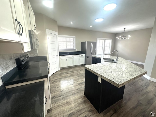 5516 W Florence Ln N, Highland, UT 84003 - kitchen with stainless steel appliances, a center island with sink, dark wood finished floors, decorative backsplash, and a chandelier